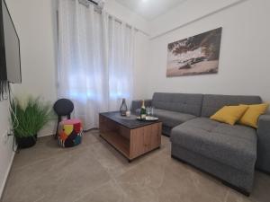 Lady Di apartments في قشتيلا: غرفة معيشة مع أريكة وطاولة قهوة