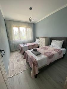 a bedroom with two beds and a rug at Şirin Villa in Macka
