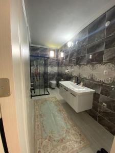 a bathroom with a sink and a shower and a toilet at Şirin Villa in Macka