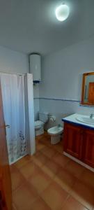 a bathroom with two toilets and a sink and a shower at Viviendas Ferrer - Can Joan Andrauet in Sant Francesc Xavier