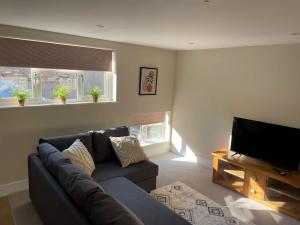 a living room with a couch and a flat screen tv at No 18 2 Bed Town Centre Apartment in Huntingdon