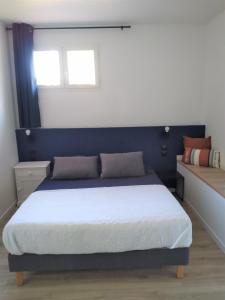 um quarto com uma cama com uma cabeceira azul em Superbe bas de villa 80 m2 très calme et frais avec vue magnifique 6 couchages em La Londe-les-Maures