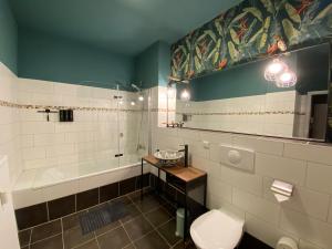 ein Badezimmer mit einer Badewanne, einem WC und einem Waschbecken in der Unterkunft Tropisches Loft mit privatem Garten in Magdeburg