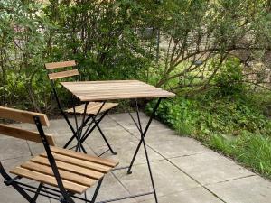 einen Holztisch und zwei Stühle neben einem Tisch und einem Stuhl in der Unterkunft Tropisches Loft mit privatem Garten in Magdeburg