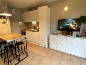 a kitchen with a tv and a table with stools at APARTAMENTO CASA TEVA Wifi-Parquing free-Terraza in Canillo