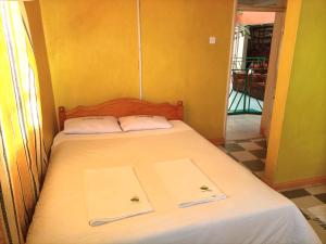 een slaapkamer met een bed met twee handdoeken erop bij New Green Pastures Guest House in Eldoret