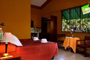 Ένα ή περισσότερα κρεβάτια σε δωμάτιο στο Cesar's Tropical Hotel