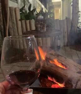 a person holding a glass of wine next to a fire at Pousada Balneário Camboriú in Balneário Camboriú