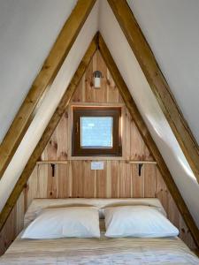 a bed in the apex of a roof at Bungalows and rooms Ivan in Žabljak