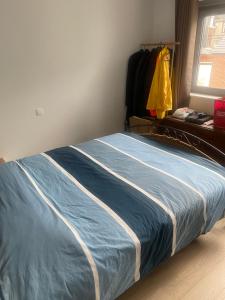 a bedroom with a large blue bed with a window at Appart centre Stavelot in Stavelot