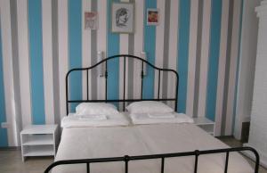 a bed in a room with blue and white stripes at BALTĀ māja in Aglona