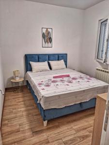 a bed in a bedroom with a blue bed frame at Studios Merdović in Budva