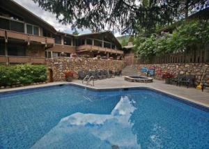 a large swimming pool in front of a house at Deluxe Three Bedroom - Aspen Alps 209 in Aspen