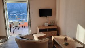 un soggiorno con TV e tavolo con sedie di Apartments Krivokapic Kotor a Kotor (Cattaro)