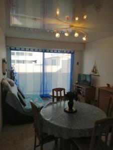 a living room with a table and a bedroom at appartement saint hilaire de riez 85270 in Saint-Hilaire-de-Riez