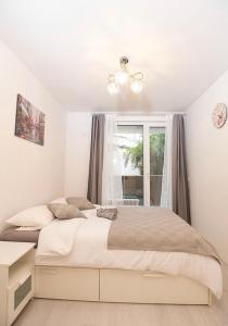 a white bedroom with a bed and a window at Top Central Apartment & Free Parking in Sofia