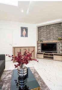 una sala de estar con un jarrón de flores sobre una mesa en Top Central Luxury Apartment & Free Parking en Sofía