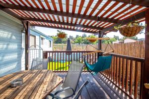 um deque com uma mesa e cadeiras e uma pérgola em הבקתה הכחולה - The blue cabin em Sha'al