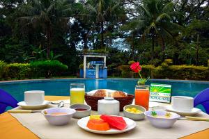 een tafel met eten en drinken naast een zwembad bij Cesar's Tropical Hotel in Villa Tunari
