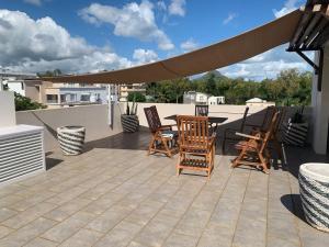 a patio with chairs and a table on a roof at Great family-friendly Appartment flic en flac MRU in Flic-en-Flac