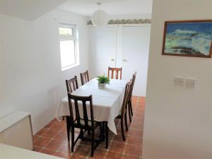 a dining room with a white table and chairs at Cottage in Frogmore near Salcombe Estuary & Beaches in Kingsbridge