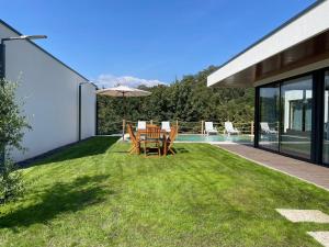patio con tavolo e sedie sull'erba di Casas da Veiga a Braga