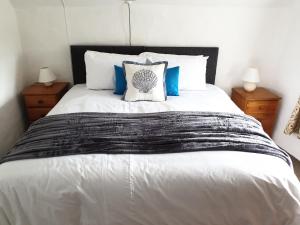 a bedroom with a large white bed with blue pillows at Cottage in Frogmore near Salcombe Estuary & Beaches in Kingsbridge