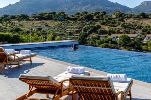 a woman in a swimming pool with a person in the water at Costa Smeralda House in Cugnana