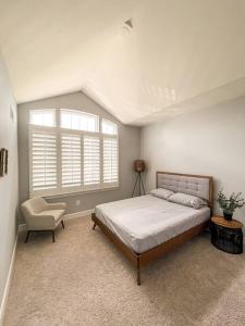 1 dormitorio con 1 cama, 1 silla y 1 ventana en LUX HOME 5 BD, GIFT CARD, GAME ROOM, and more! en Ashburn