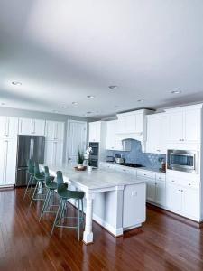 una cocina blanca con una gran mesa y sillas blancas en LUX HOME 5 BD, GIFT CARD, GAME ROOM, and more!, en Ashburn