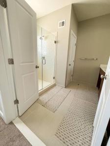 baño blanco con ducha y puerta de cristal en LUX HOME 5 BD, GIFT CARD, GAME ROOM, and more! en Ashburn