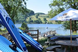 a table with an umbrella next to a lake at Redwood Lodge in Penrith