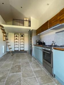 a kitchen with blue cabinets and a stove top oven at Appartement centre Apt Bèlavista luberon in Apt