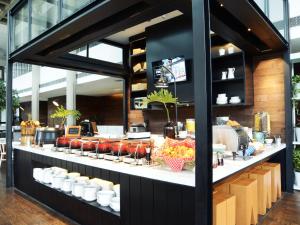 a counter filled with lots of different types of food at Morrissey Hotel Residences in Jakarta