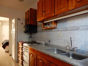 a kitchen with a sink and a refrigerator at Edificio Parana in Santa Rosa