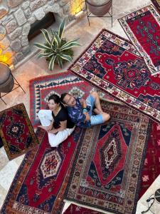two people laying on rugs on the floor at Under Cave Cappadocia in Urgup