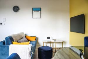 a living room with a blue couch and a table at Funky Flat - City Centre - Free Parking in Norwich