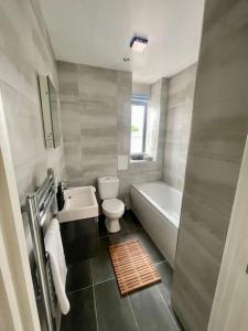 a bathroom with a tub and a toilet and a sink at Funky Flat - City Centre - Free Parking in Norwich