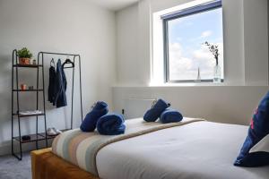 a bedroom with a bed with blue stuffed animals on it at Funky Flat - City Centre - Free Parking in Norwich