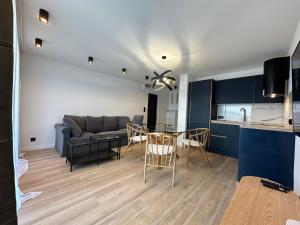 eine Küche und ein Wohnzimmer mit einem Sofa und einem Tisch in der Unterkunft Apartament Michałek in Mielno