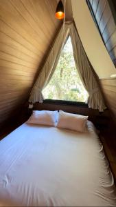 a bed in a tent with a window at Chalé Villa Nature in Campos do Jordão