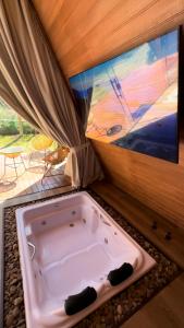 a jacuzzi tub in a room with a tv at Chalé Villa Nature in Campos do Jordão