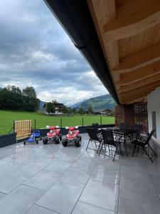 eine Terrasse mit einem Tisch und zwei Rollern für Mobilität in der Unterkunft Apart Egger in Schwendau