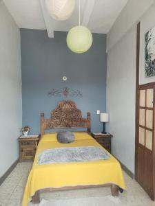 a bedroom with a bed with a yellow blanket at Casa Chelito con Terraza in Guanajuato