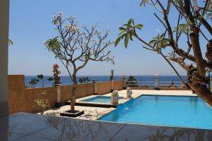 a swimming pool with a view of the ocean at Barong Cafe Bungalow and Restaurant in Amed