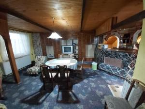 ein Wohnzimmer mit einem Tisch und Stühlen im Zimmer in der Unterkunft Julija Pansion in Senta