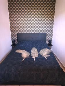 Un dormitorio con una cama con dos plumas. en 2 pièces proche plage + parking, en Golfe-Juan