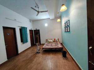 Un ragazzo in piedi in una stanza con un letto di Housefull Residency a Khandagiri
