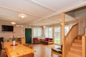 a living room with a wooden table and a television at Vila RUNA in Plateliai