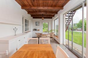 a kitchen with white cabinets and a wooden ceiling at Vila RUNA in Plateliai